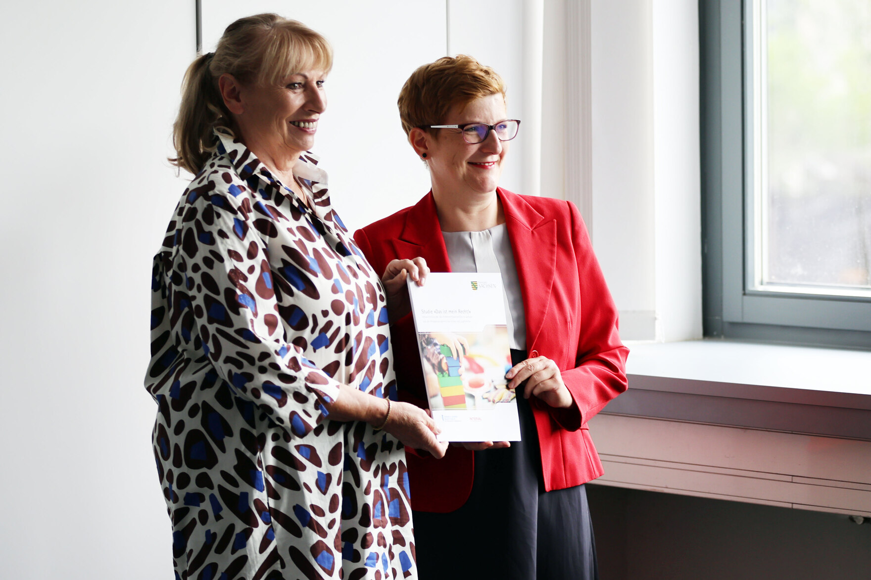 Staatsministerin Köpping und Kinderbeauftragte Rüthrich halten die Studie "Das ist mein Recht!" in der Hand